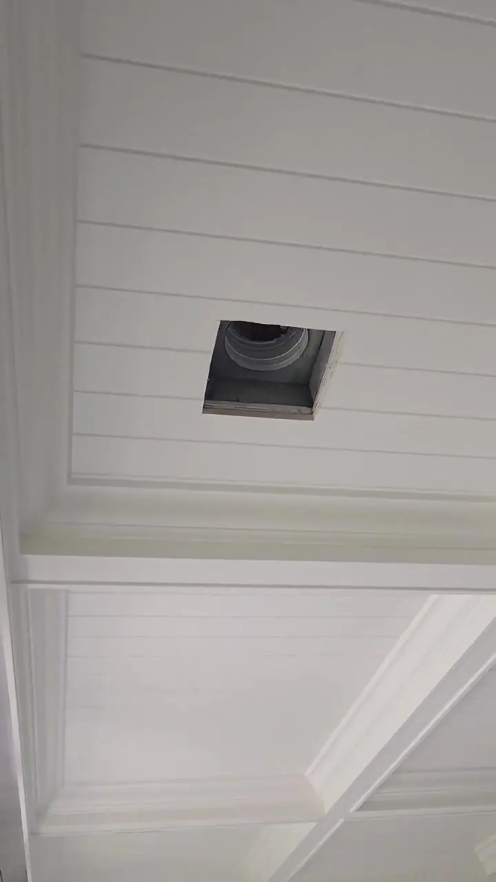 Close pass across a coffered ceiling showing the beam faces and returns finished in white.