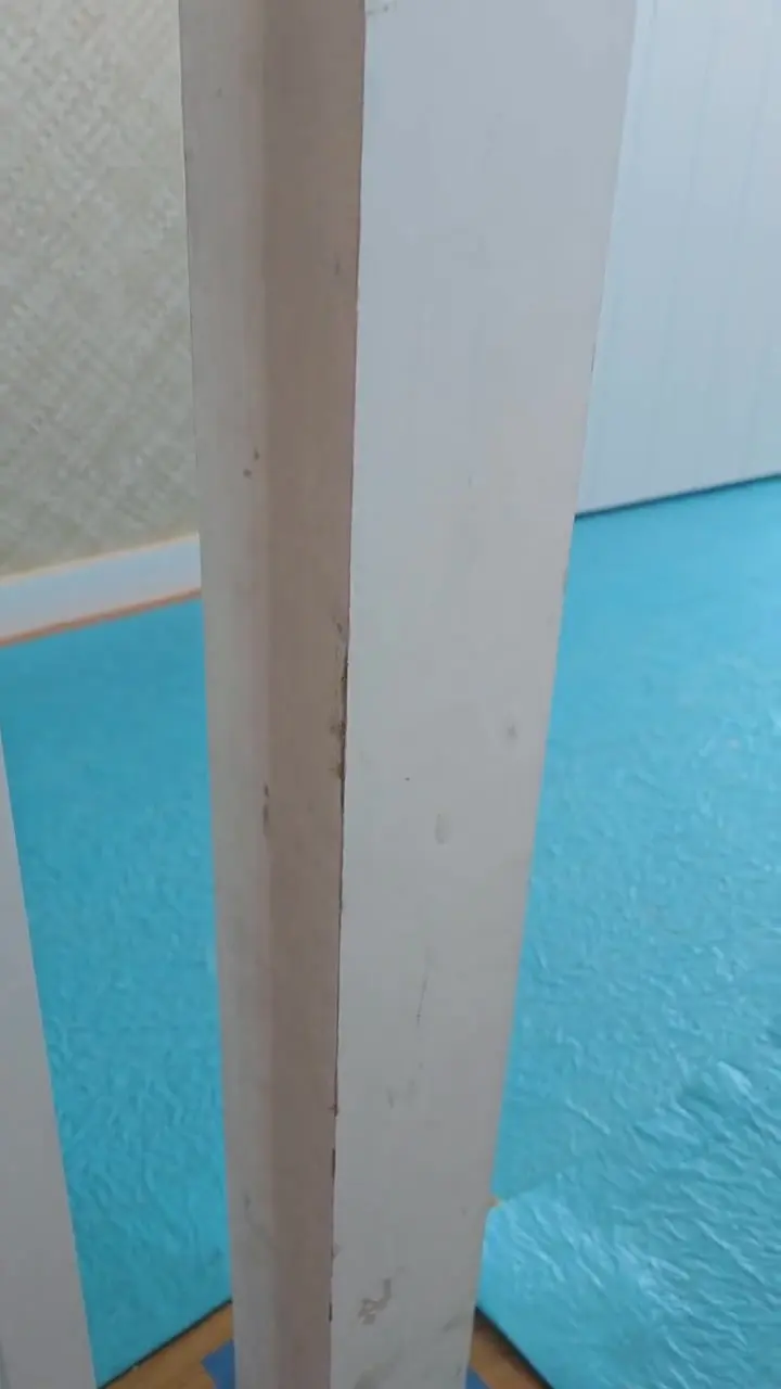 A structural post part-finished, with floor protection down and the raw and coated faces both visible.