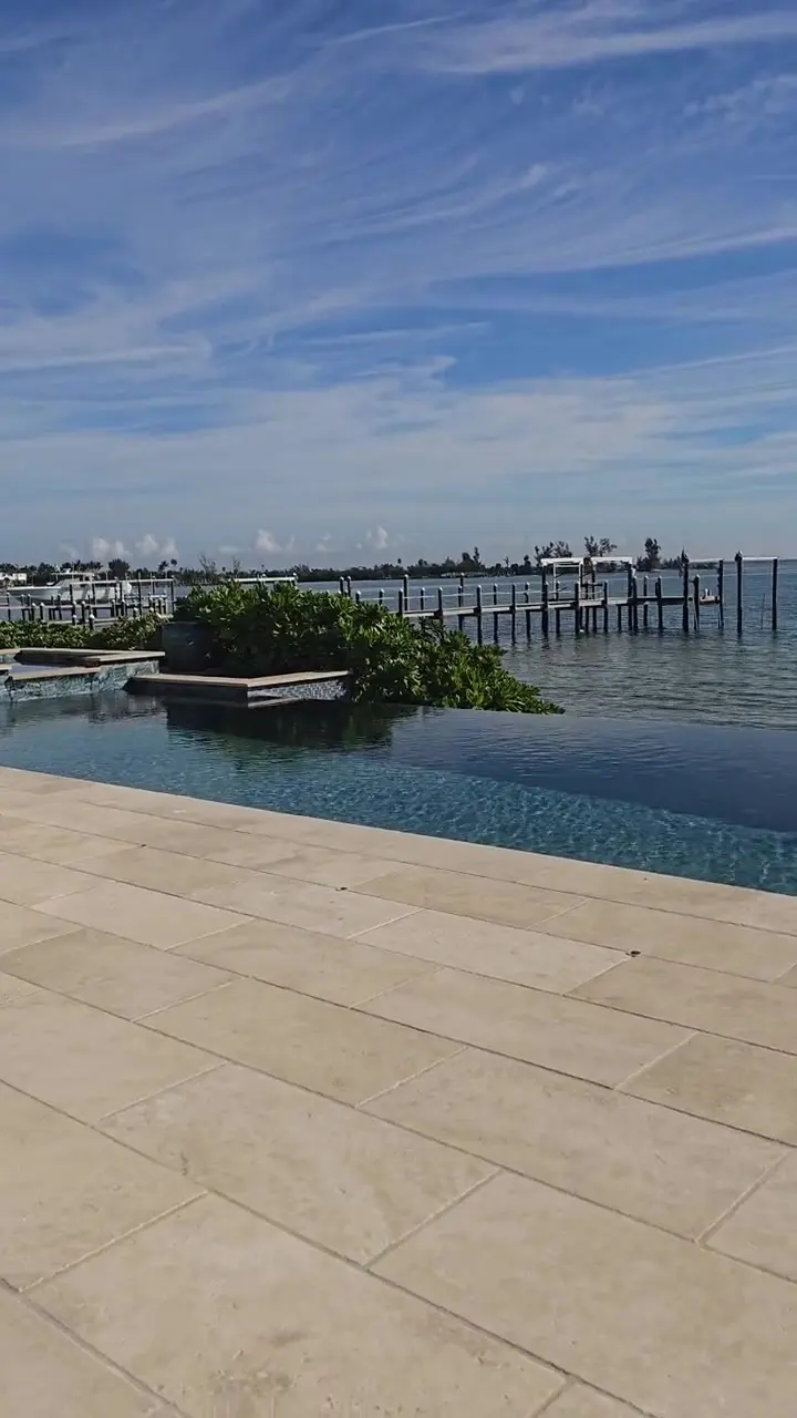 Infinity pool and terrace overlooking the water at a Gulf Coast property.