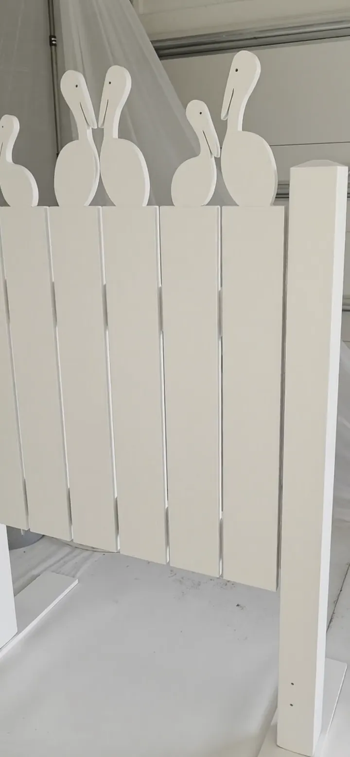 The same pelican picket fence finished in soft white — sprayed off site so every edge and cut-out is coated evenly before it is set.