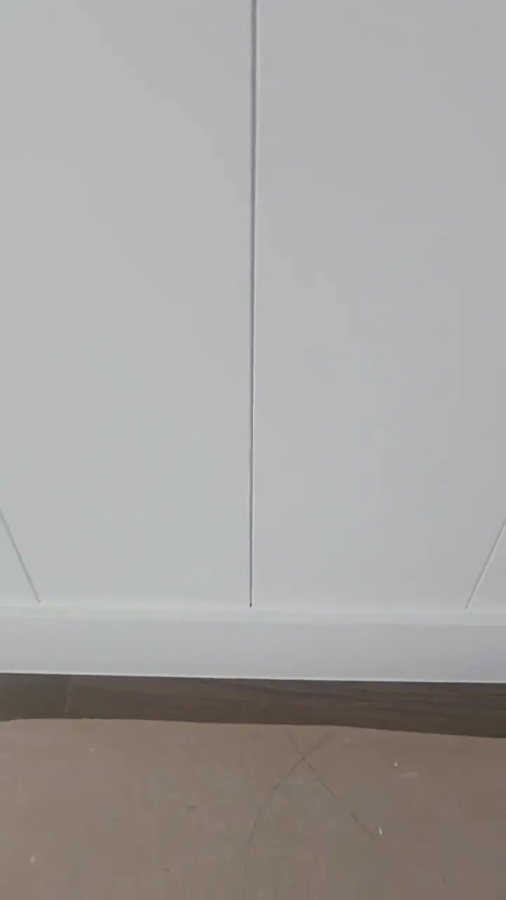 Vertical shiplap wall finished in white, showing the consistency of the reveal between boards.