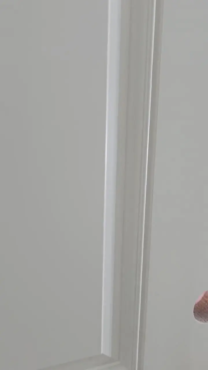 Close detail of the line where finished wall meets trim, with no build-up or overlap.
