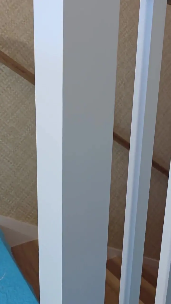 Painted columns set against a stained wood ceiling in an open coastal interior.