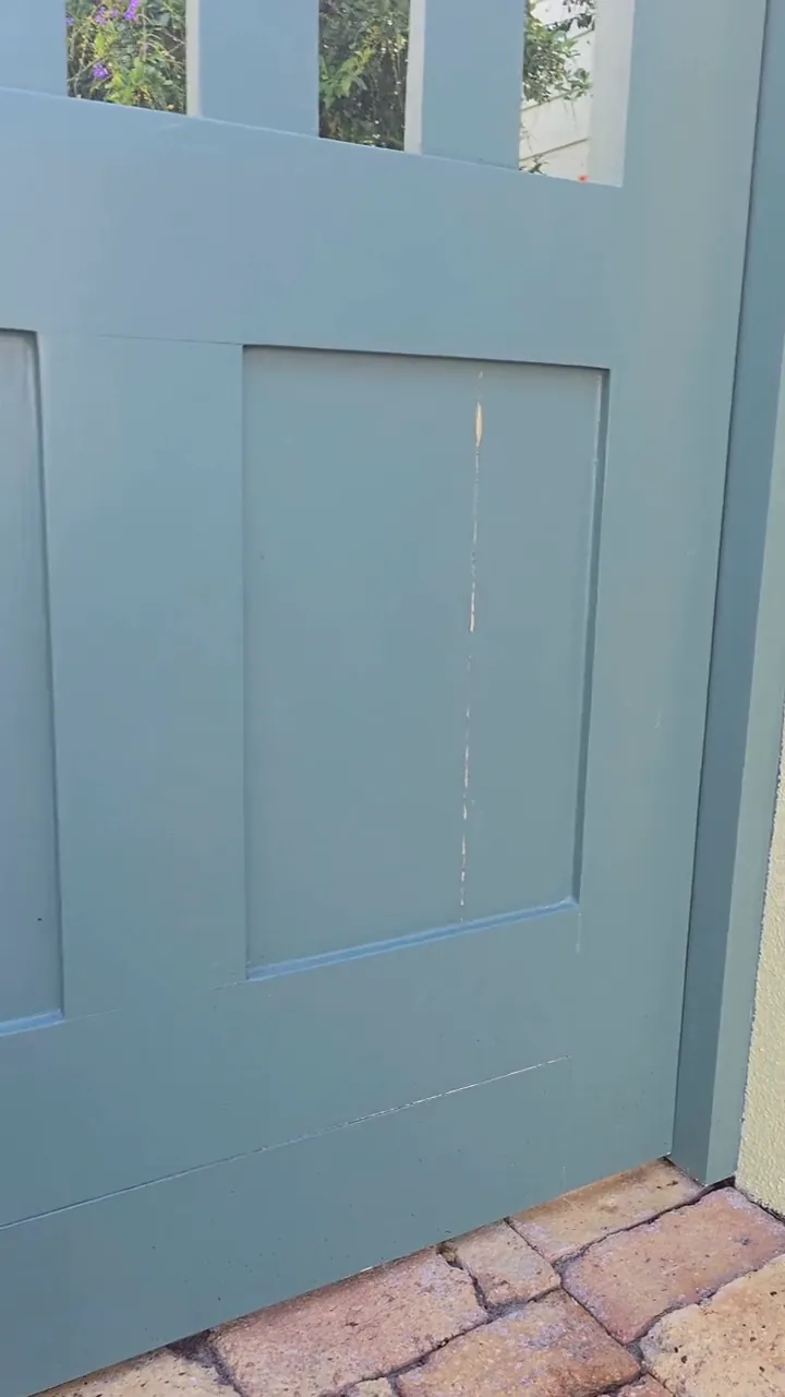 A split running the full height of a gate panel, filled and sanded flush before any colour goes on — the stage that decides whether the finish lasts a season or a decade.